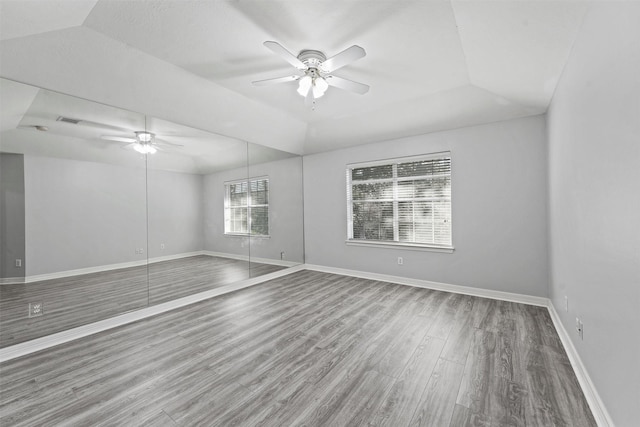 spare room featuring a tray ceiling, ceiling fan, and hardwood / wood-style flooring