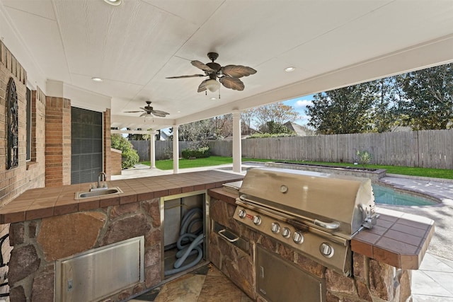 view of patio / terrace featuring a fenced in pool, area for grilling, ceiling fan, and sink