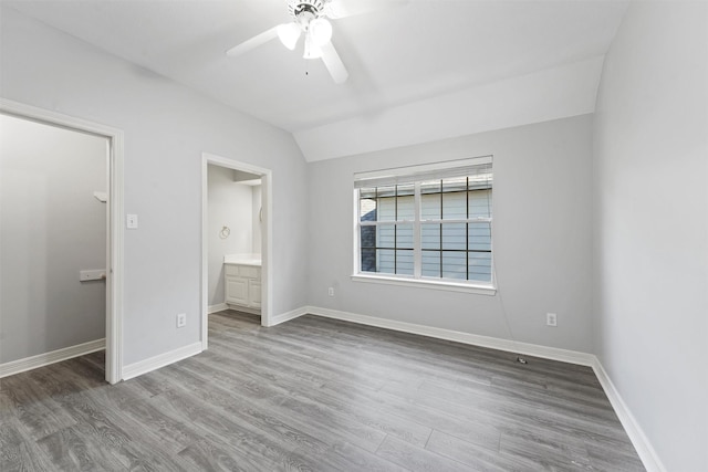 unfurnished bedroom with hardwood / wood-style flooring, ceiling fan, lofted ceiling, and ensuite bathroom