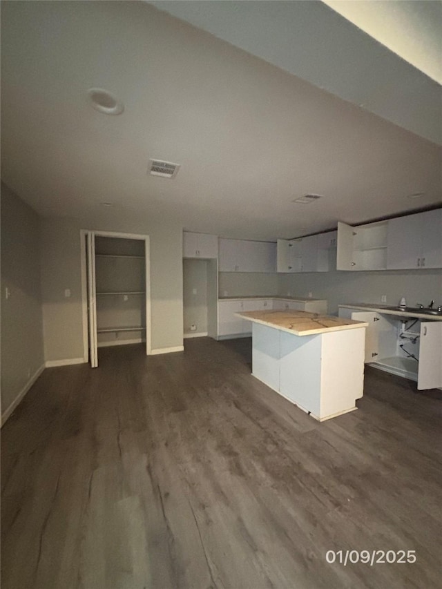 kitchen featuring dark hardwood / wood-style flooring, a center island, and white cabinets