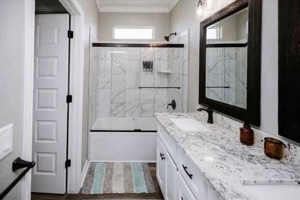 bathroom featuring shower / bath combination with glass door, vanity, and crown molding