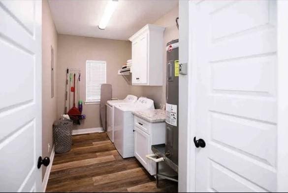 laundry area with washer and dryer, dark hardwood / wood-style floors, cabinets, and water heater