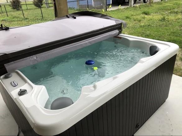 exterior space featuring a yard and a hot tub