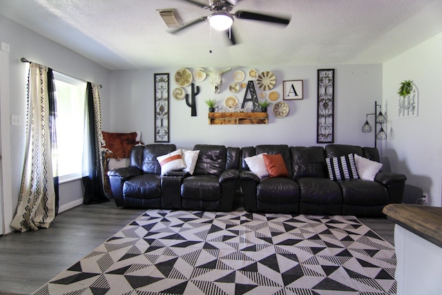 living area with dark wood-style floors, ceiling fan, a textured ceiling, and visible vents