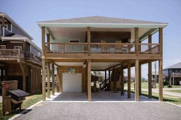 view of front of home featuring a balcony, a garage, and a carport