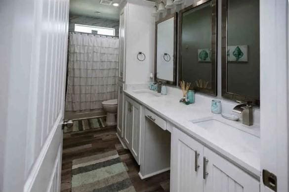 bathroom with hardwood / wood-style flooring, vanity, toilet, and a shower with curtain