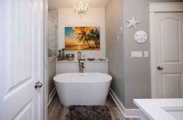 bathroom featuring a tub, vanity, a chandelier, and hardwood / wood-style flooring