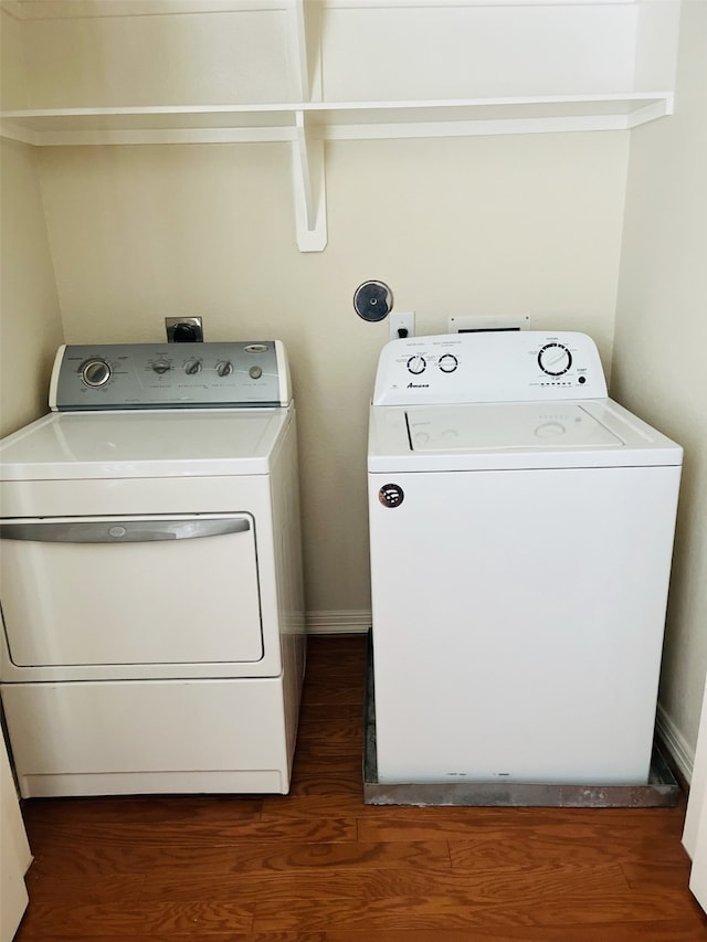 clothes washing area featuring washer and dryer and dark wood-type flooring