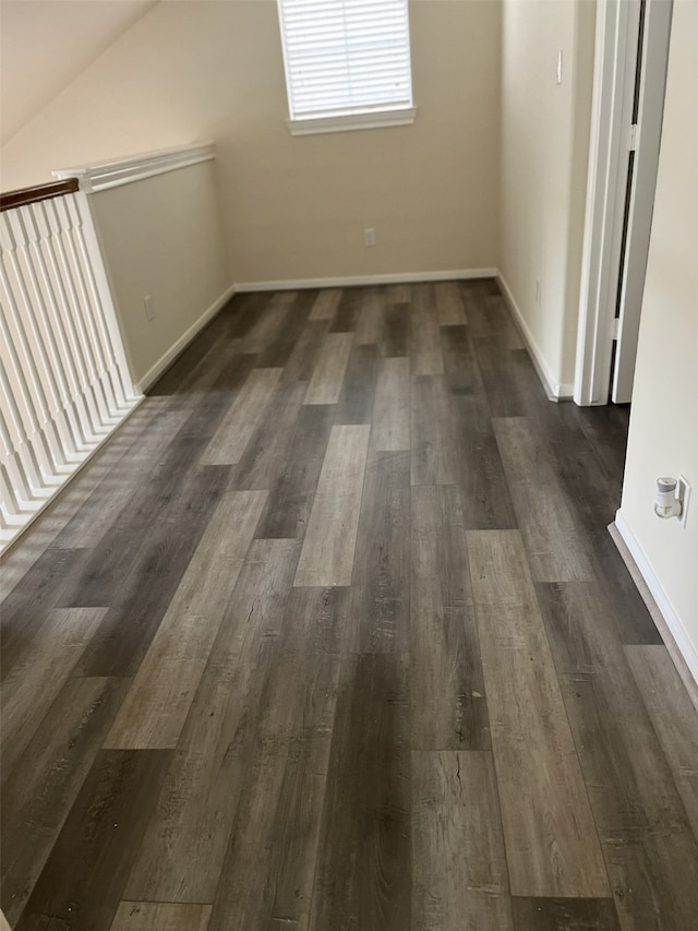 bonus room with dark hardwood / wood-style floors and vaulted ceiling