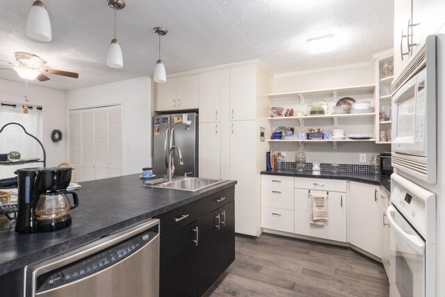 kitchen featuring sink, a textured ceiling, white cabinets, and appliances with stainless steel finishes