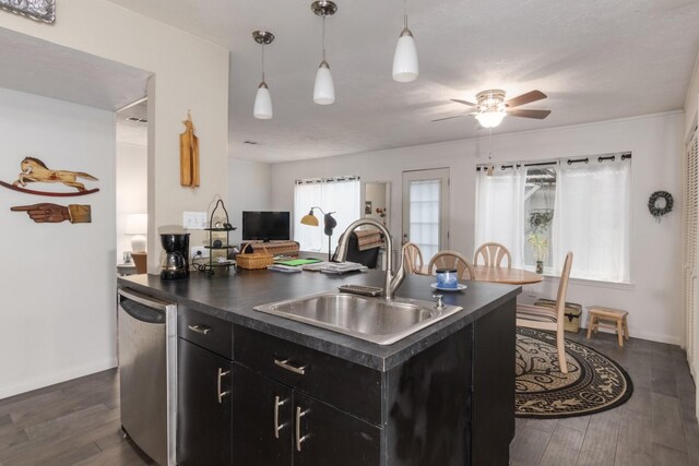 kitchen with dark wood-type flooring, sink, a center island with sink, stainless steel dishwasher, and ceiling fan