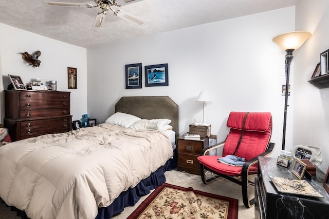 bedroom featuring ceiling fan, light colored carpet, and a textured ceiling