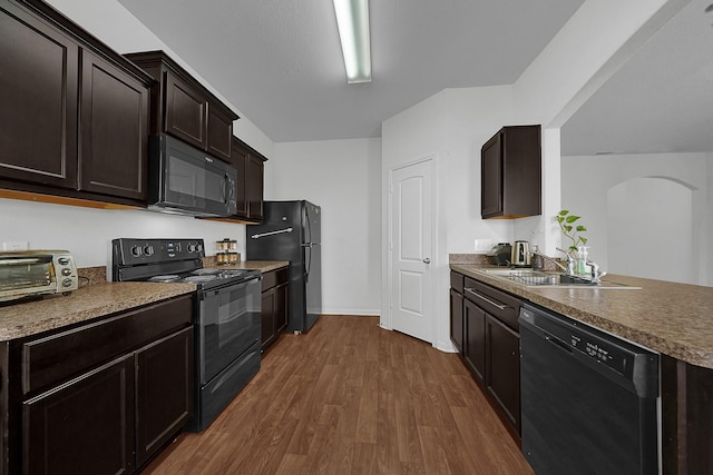 kitchen with black appliances, dark wood-type flooring, sink, and dark brown cabinets