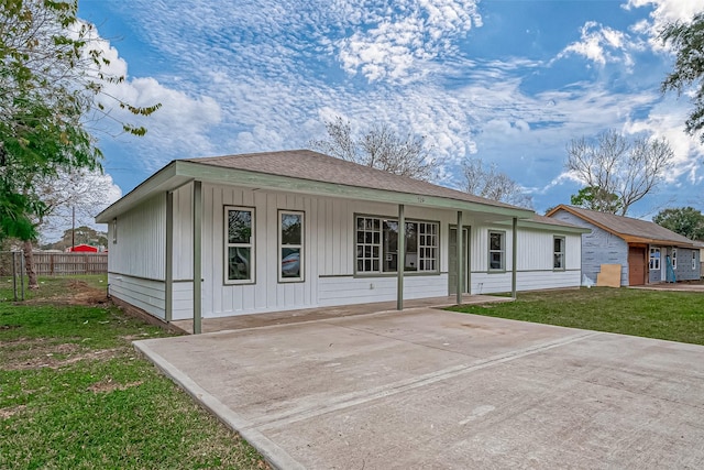 back of property with a lawn and covered porch