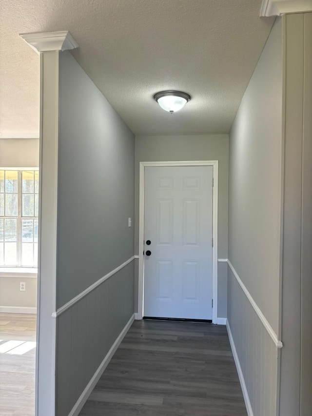 doorway to outside with dark hardwood / wood-style flooring and a textured ceiling