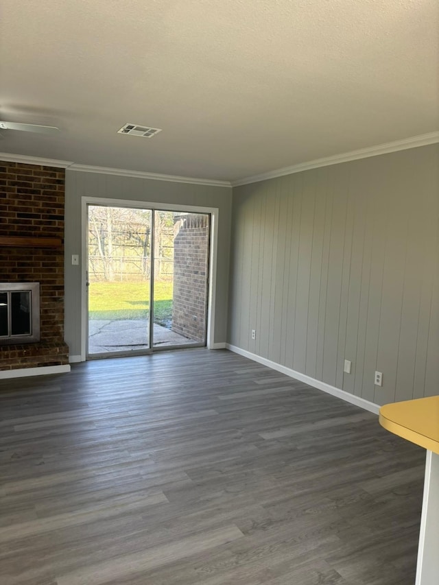 unfurnished living room with crown molding, a fireplace, and dark wood-type flooring