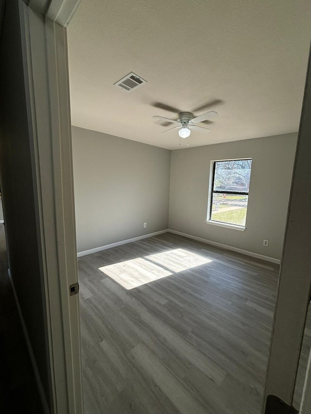 empty room featuring ceiling fan and wood-type flooring