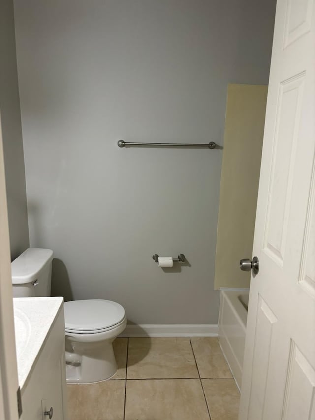 bathroom featuring tile patterned flooring, vanity, toilet, and a bathing tub