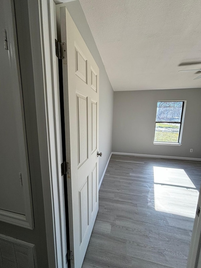 unfurnished room featuring dark hardwood / wood-style floors, ceiling fan, and a textured ceiling