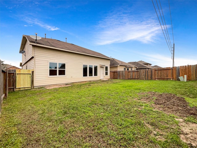 rear view of property featuring a yard