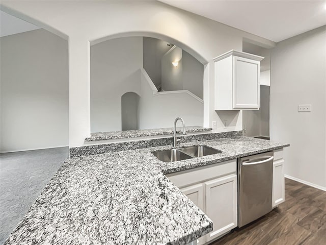 kitchen featuring white cabinets, stainless steel dishwasher, light stone countertops, and sink