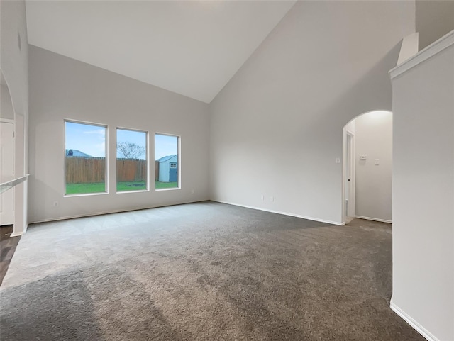 carpeted spare room featuring high vaulted ceiling