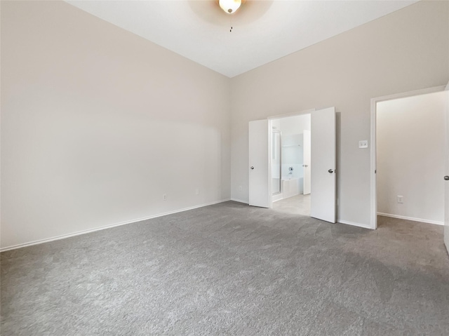 empty room featuring carpet and a towering ceiling