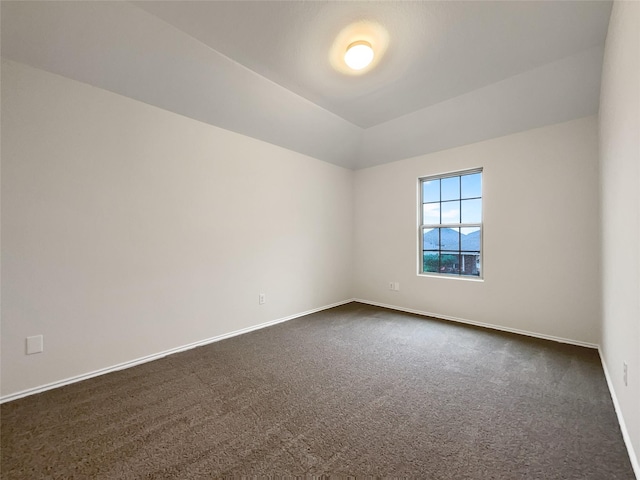 carpeted empty room featuring lofted ceiling