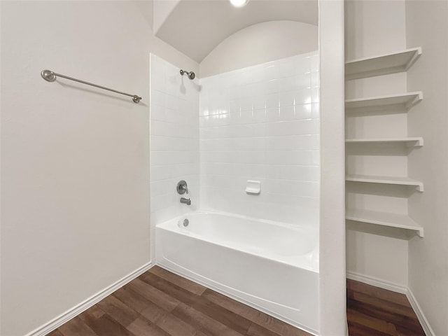 bathroom with hardwood / wood-style floors, shower / washtub combination, and vaulted ceiling