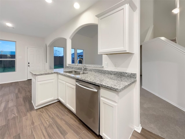 kitchen featuring stainless steel dishwasher, light stone counters, white cabinetry, and sink