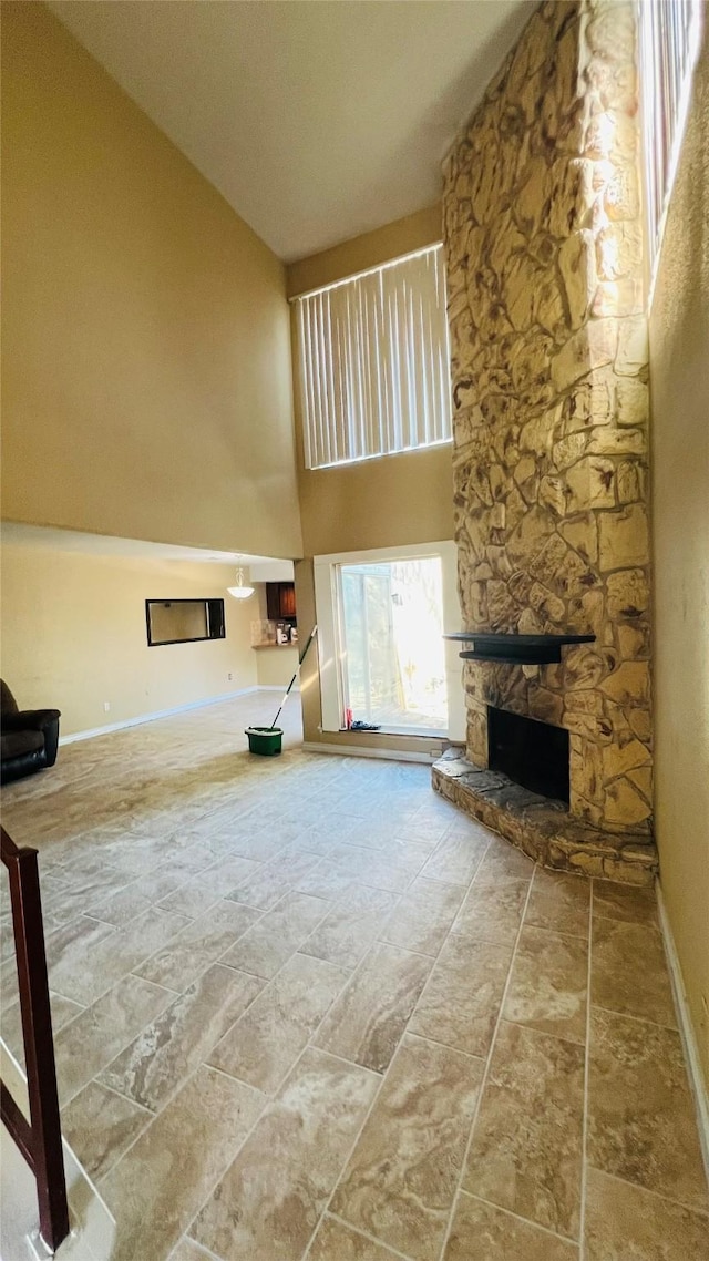 unfurnished living room featuring a fireplace and a towering ceiling