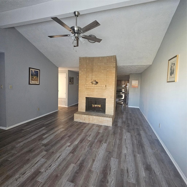 unfurnished living room featuring a fireplace, a textured ceiling, lofted ceiling with beams, and dark hardwood / wood-style floors