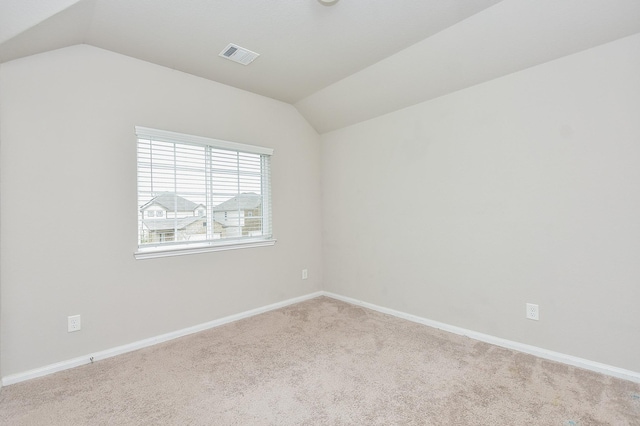 empty room with light carpet and lofted ceiling