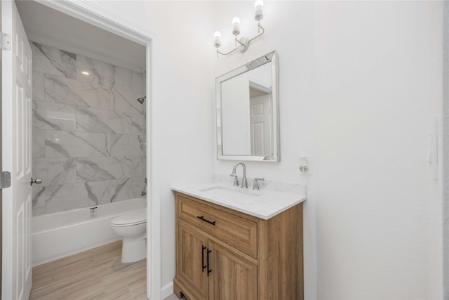 full bathroom with toilet, vanity, hardwood / wood-style floors, and tiled shower / bath combo