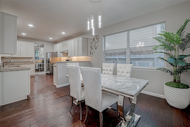 dining area featuring sink and dark wood-type flooring