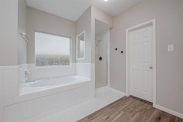 bathroom with separate shower and tub and wood-type flooring