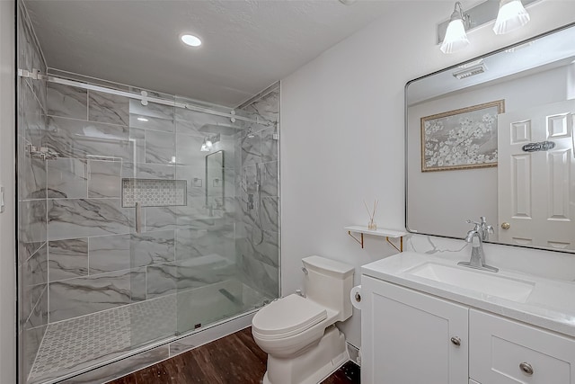 bathroom with wood-type flooring, vanity, toilet, and walk in shower