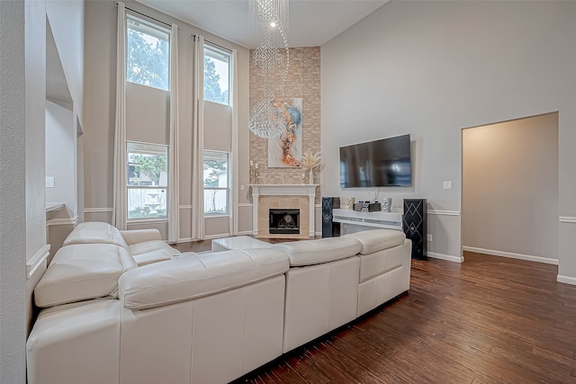 living room featuring dark hardwood / wood-style floors, high vaulted ceiling, and an inviting chandelier