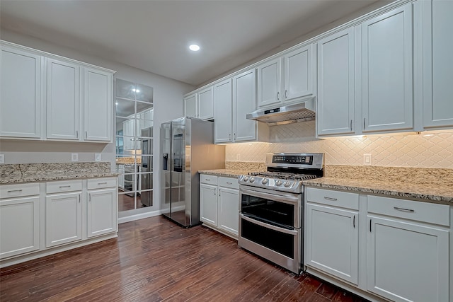 kitchen featuring white cabinets, light stone counters, stainless steel appliances, and dark wood-type flooring