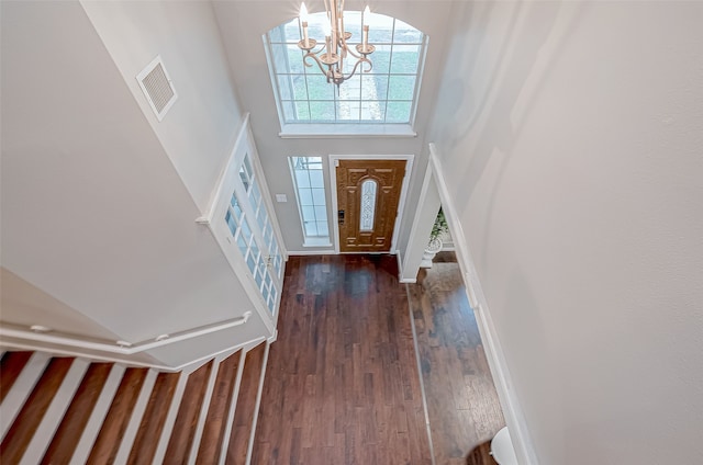 foyer featuring a high ceiling, an inviting chandelier, and dark wood-type flooring