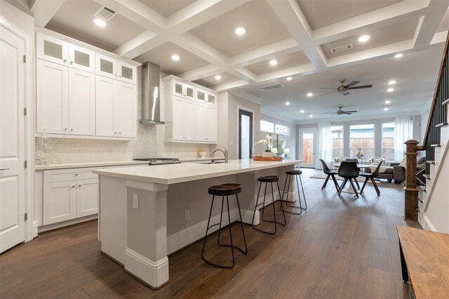 5636 Darling St, Houston, TX 77007 - kitchen featuring coffered ceiling, wall chimney range hood, ceiling fan, recessed lighting, and a kitchen bar