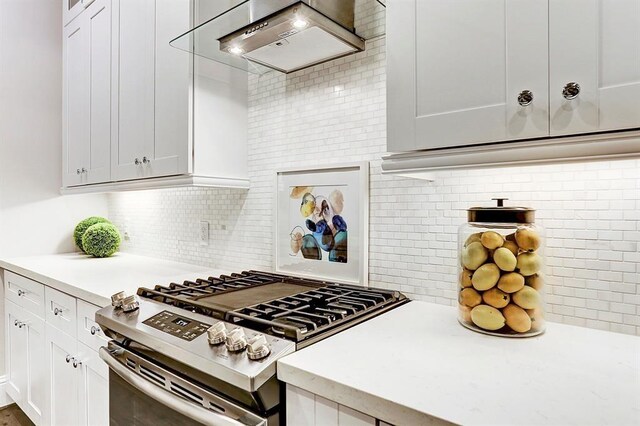 5636 Darling St, Houston, TX 77007 - kitchen featuring gas range, custom exhaust hood, light countertops, tasteful backsplash, and white cabinets