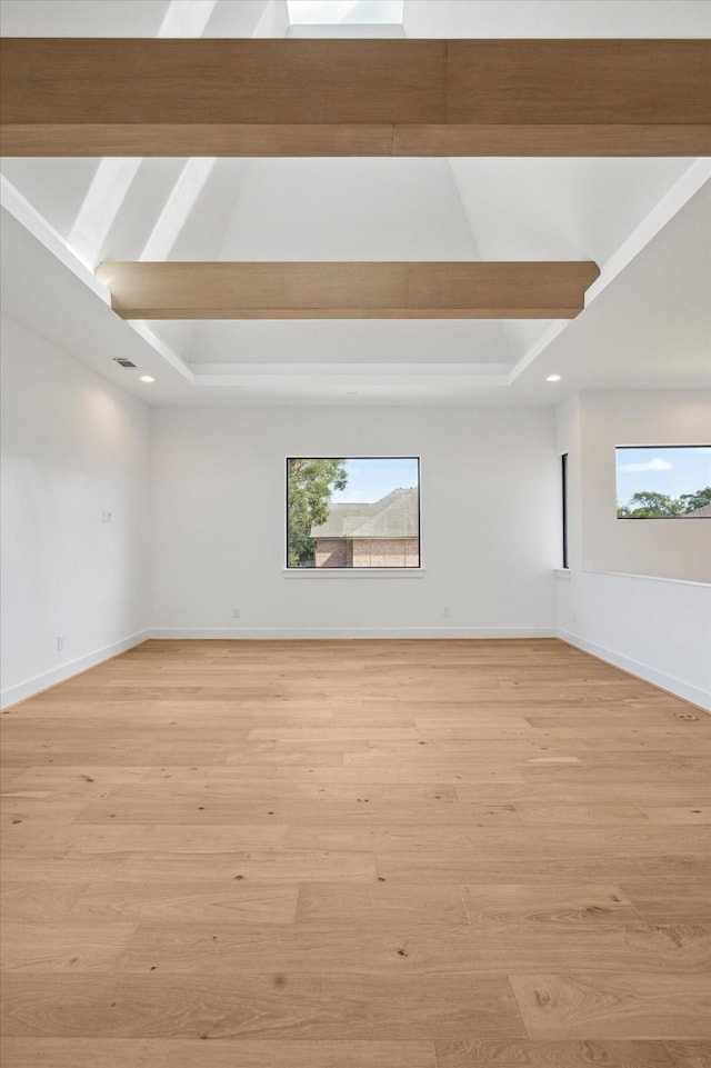 unfurnished room featuring light hardwood / wood-style floors and a raised ceiling