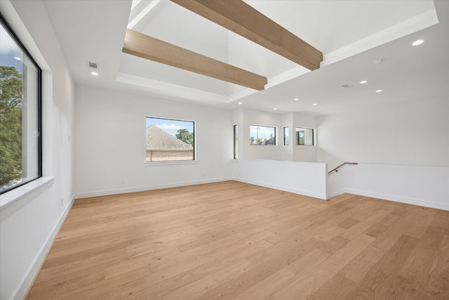 unfurnished room featuring beamed ceiling and light wood-type flooring