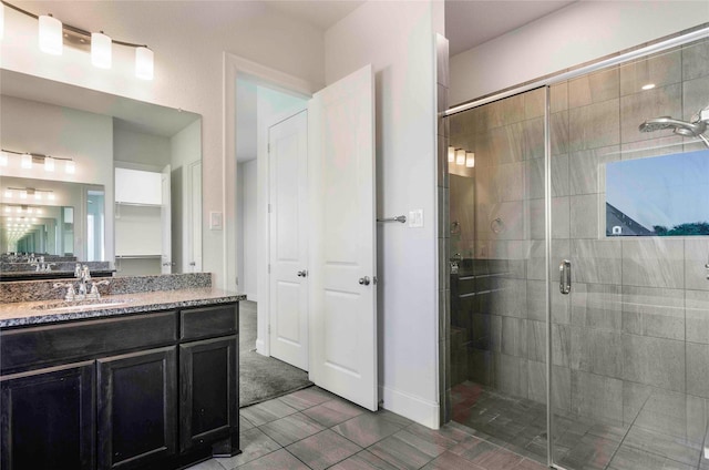 bathroom with tile patterned flooring, vanity, and walk in shower