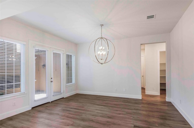 unfurnished dining area with a chandelier, french doors, and dark hardwood / wood-style floors