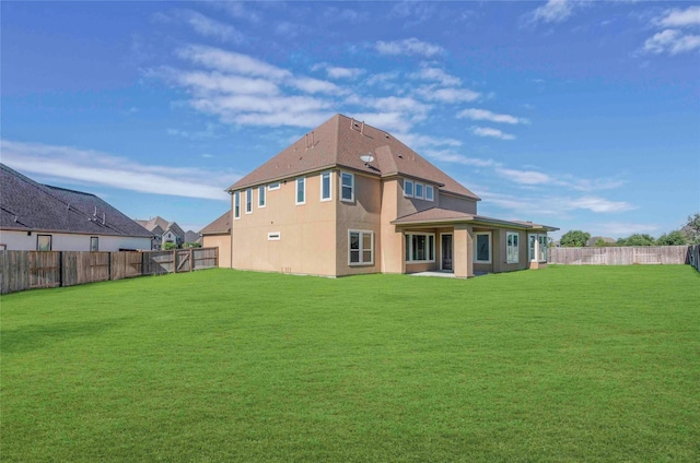 rear view of property featuring a lawn