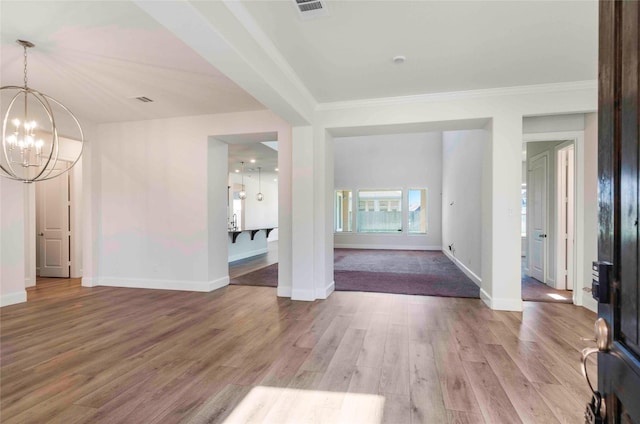 entryway featuring hardwood / wood-style floors, crown molding, and a notable chandelier