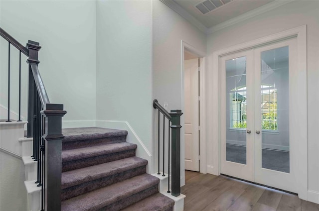 interior space featuring wood-type flooring, crown molding, and french doors