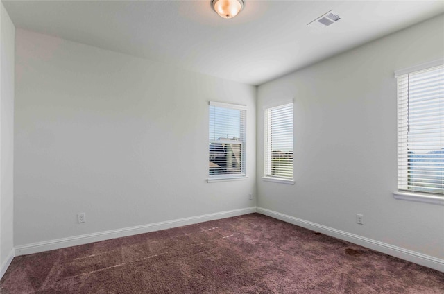 unfurnished room with dark carpet